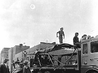 1975-18  1 maja 1975  Jawor, ul. Poniatowskiego  Obchody 1 maja - Święto Pracy    Uczestnicy pochodu zmierzający w kierunku trybuny honorowej.  Skoczkowie na trampolinach z Miejskiego Klubu Sportowego "Victoria".