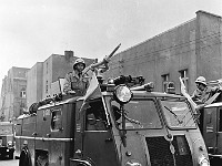 1975-19  1 maja 1975  Jawor, ul. Józefa Poniatowskiego  Obchody 1 maja - Święto Pracy    Uczestnicy pochodu zmierzający w kierunku trybuny honorowej.  Wozy i pracownicy Straży Pożarnej.