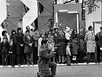 1975-25  1 maja 1975  Jawor, ul. Wrocławska  Obchody 1 maja - Święto Pracy    Mieszkańcy zgromadzeni wzdłuż trasy pochodu w pobliżu trybuny honorowej.  W centrum: Janusz Kredoszyński - założyciel i kierownik Amatorskiego Klubu Filmowego "Jawornik".