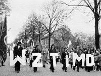 1975-34  1 maja 1975  Jawor, ul. Wrocławska  Obchody 1 maja - Święto Pracy    Uczestnicy pochodu prezentujący się przed trybuną honorową.  Pracownicy Wojewódzkiego Zakładu Transportu i Maszyn Drogowych (WZTiMD).  W drugim rzędzie pierwszy od prawej w jasnym płaszczu: Jerzy Kowalik - dyrektor zkładu.