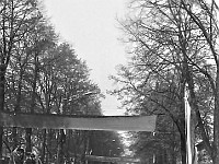 1980-02  1 maja, (prawdopodobnie rok 1980)  Jawor, ul. Wrocławska  Obchody 1 maja - Święta Pracy    Mieszkańcy miasta oczekujący w okolicach trybuny honorowej na uczestników pochodu pierwszomajowego.  Na środku ulicy: Janusz Kredoszyński - założyciel i operator Amatorskiego Klubu Filmowego "Jawornik".