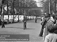 1980-69  1 maja, (prawdopodobnie rok 1980)  Jawor, ul. Wrocławska  Obchody 1 maja - Święta Pracy    Uczestnicy pochodu pierwszomajowego prezentujący się przed trybuną honorową niosący wizerunki przodowników pracy.