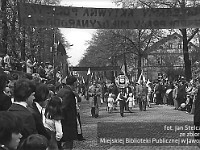 1980-76  1 maja, (prawdopodobnie rok 1980)  Jawor, ul. Wrocławska  Obchody 1 maja - Święta Pracy    Uczestnicy pochodu pierwszomajowego prezentujący się przed trybuną honorową.  Pracownicy Spółdzielni Pracy Krawieckiej im. Obrońców Pokoju.