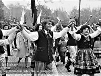 1980-82  1 maja, (prawdopodobnie rok 1980)  Jawor, ul. Wrocławska  pochód    Obchody 1 maja - Święta Pracy  Uczestnicy pochodu pierwszomajowego - członkowie zespołu ludowego - prezentujący się przed trybuną honorową, zlokalizowaną naprzeciwko Zasadniczej Szkoły Zawodowej.