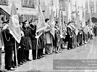 1983-15  1 maja (prawdopodobnie rok 1983)  Jawor, Rynek  Obchody 1 maja - Święta Pracy     Poczty sztandarowe przed wejściem głównym do ratusza.