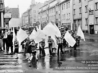 1983-18  1 maja (prawdopodobnie rok 1983)  Jawor, skrzyżowanie ul. Grunwaldzkiej i ul. Poniatowskiego  Obchody 1 maja - Święto Pracy     Uczestnicy pochodu zmierzający w kierunku trybuny honorowej.