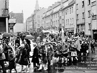 1983-19  1 maja (prawdopodobnie rok 1983)  Jawor, skrzyżowanie ul. Grunwaldzkiej i ul. Poniatowskiego  Obchody 1 maja - Święto Pracy     Uczestnicy pochodu zmierzający w kierunku trybuny honorowej.