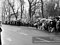1983-23  1 maja (prawdopodobnie rok 1983)  Jawor, ul. Wyszyńskiego (dawn. Rapackiego)  Obchody 1 maja - Święto Pracy     Uczestnicy pochodu zmierzający w kierunku trybuny honorowej i mieszkańcy zgromadzeni wzdłuż trasy przemarszu.