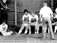1986-87 09  1986  Jawor, ul. Parkowa 8, stadion miejski  Mecz ligowy Kuźni Jawor      Od lewej na murawie siedzi Sławomir Bliskowski, Marek Grzęda stoi, dalej siedzą Michał Lenkiewicz, Andrzej Ignatiuk, tyłem trener Waldemar Wójcicki, Krzysztof Ziemba.
