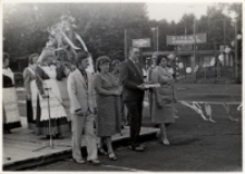 Gospodarze dożynek z bochnem, za nimi gospodynie z Kuraszkowa z wieńcem, wrzesień 1983 r. [Dokument ikonograficzny]