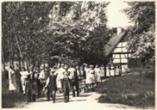 Zespoły ludowe z gminy Oborniki Śląskie z muzyką i śpiewem idą polną drogą przez opolski skansen, maj 1984 r. [Dokument ikonograficzny]